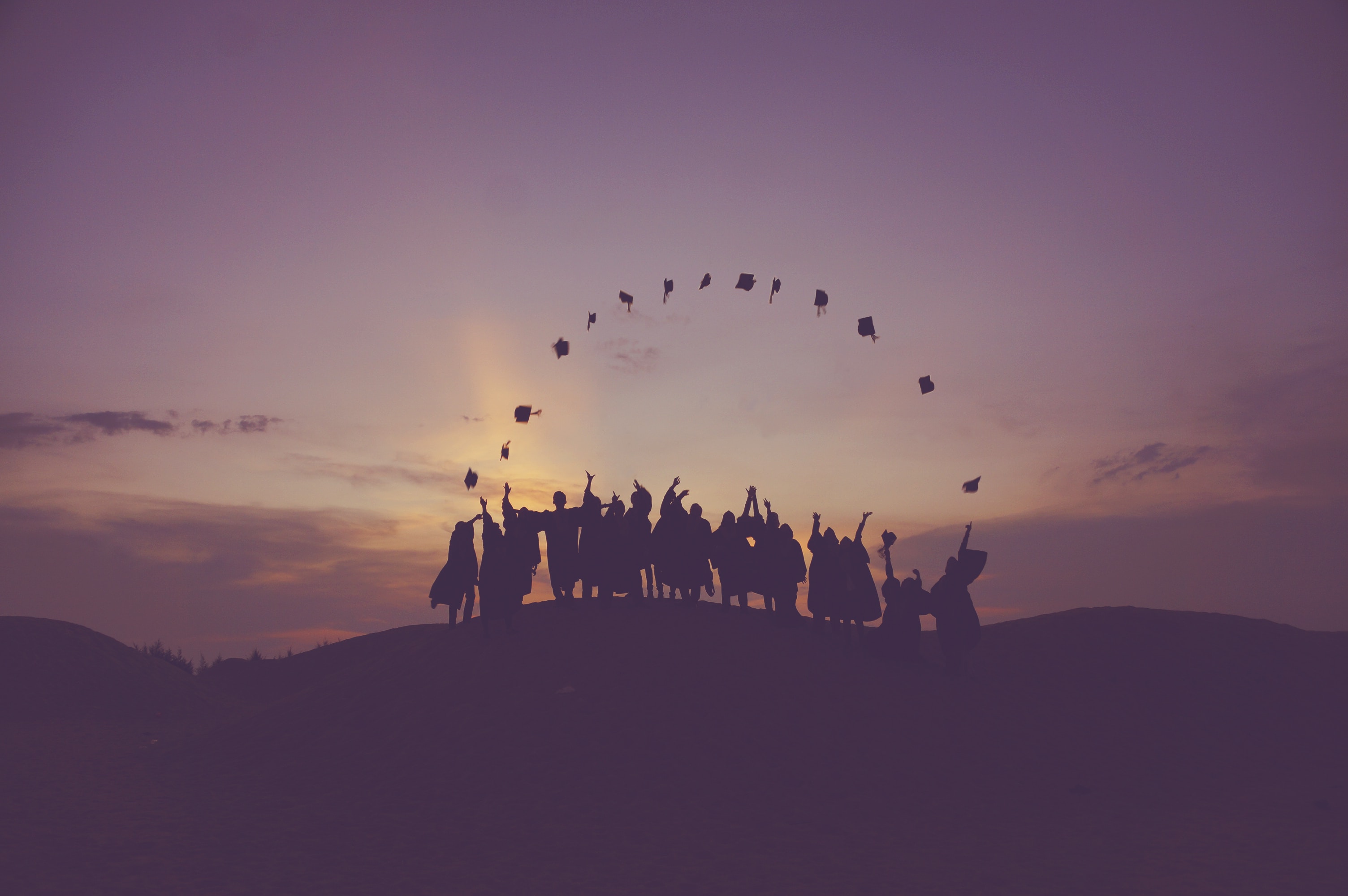 nursing graduates throwing their graduation caps into the air