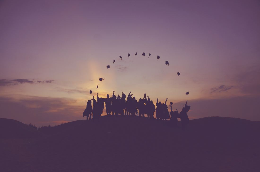 nursing graduates throwing their graduation caps into the air